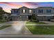 Charming townhomes at dusk with well-maintained lawns and attached garages with stone-trimmed facade at 9768 Pembrooke Pines Dr, Sun City Center, FL 33573