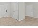 Hallway with white doors and neutral tile floors offering a clean and minimalist design at 9768 Pembrooke Pines Dr, Sun City Center, FL 33573