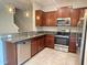 Modern kitchen with stainless steel appliances, granite countertops, and warm wood cabinetry at 9768 Pembrooke Pines Dr, Sun City Center, FL 33573