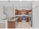 Stylish kitchen featuring stainless steel appliances, granite counters, and modern lighting fixtures at 9768 Pembrooke Pines Dr, Sun City Center, FL 33573
