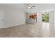 Spacious living room area with neutral tile flooring and an open layout to the kitchen at 9768 Pembrooke Pines Dr, Sun City Center, FL 33573