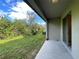Covered patio overlooking green space with mature trees, providing a serene outdoor living area at 9768 Pembrooke Pines Dr, Sun City Center, FL 33573