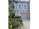 Inviting townhouse featuring an attached garage and lush landscaping at 9958 Ashburn Lake Dr, Tampa, FL 33610