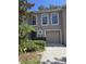 Charming townhome featuring a one-car garage and neatly maintained front yard landscaping at 9958 Ashburn Lake Dr, Tampa, FL 33610