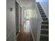 Hallway features hardwood floors, stairs, and a clear view of the front door leading to the outside at 9958 Ashburn Lake Dr, Tampa, FL 33610