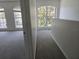 Upstairs hallway with carpet and bright light from large windows overlooking foliage at 9958 Ashburn Lake Dr, Tampa, FL 33610