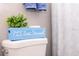 A blue decoration reading, 'PLS Seat Yourself' rests on top of the toilet in the bathroom at 1004 Osage St, Clearwater, FL 33755