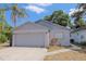 Charming single-story home featuring a two-car garage, landscaped yard, and traditional architectural details at 1004 Osage St, Clearwater, FL 33755