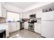 Modern kitchen features white cabinets, stainless steel appliances, and hardwood floors at 1004 Osage St, Clearwater, FL 33755