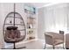 Bright living room featuring a hanging chair, shelving, and neutral color palette at 1004 Osage St, Clearwater, FL 33755