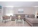 Spacious living room with a sectional sofa, glass coffee table, and modern decor at 1004 Osage St, Clearwater, FL 33755