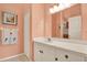 Well-lit bathroom with a vanity, white countertops, and an oversized mirror at 10597 Alvarado Ct, Seminole, FL 33772