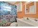 Colorful bathroom with a tropical shower curtain, sink, and built in cabinet at 10597 Alvarado Ct, Seminole, FL 33772