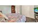 Comfortable bedroom with light green walls, white closet doors, and floral bedding at 10597 Alvarado Ct, Seminole, FL 33772