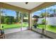 Screened lanai with a view of the green backyard and plants at 10597 Alvarado Ct, Seminole, FL 33772