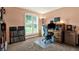 Home office with a large window, work desk, and carpeted flooring at 10597 Alvarado Ct, Seminole, FL 33772
