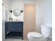 Bathroom featuring navy vanity with round mirror, designer fixtures, and a linen closet at 108 5Th Ave, St Pete Beach, FL 33706