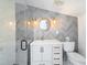Beautiful bathroom with gray herringbone tile accent wall, glass shower door, and modern vanity at 108 5Th Ave, St Pete Beach, FL 33706