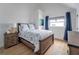 Comfortable bedroom with natural light, wood floors, and a queen-size bed featuring coastal-themed decor at 108 5Th Ave, St Pete Beach, FL 33706