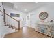 Bright entryway boasts wood floors, white walls, staircase, and coastal decor leading to a warm and inviting atmosphere at 108 5Th Ave, St Pete Beach, FL 33706