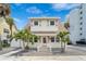Charming two-story home with a unique roofline, a light pink door, and lovely palm trees at 108 5Th Ave, St Pete Beach, FL 33706
