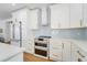 A modern kitchen with white cabinets, quartz countertops, and stainless steel appliances at 108 5Th Ave, St Pete Beach, FL 33706