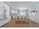 Bright, stylish kitchen featuring white cabinets, wood floors, island with seating, and stunning view from the window at 108 5Th Ave, St Pete Beach, FL 33706