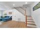 Cozy living room featuring stylish staircase, wood floors, and a comfortable blue couch at 108 5Th Ave, St Pete Beach, FL 33706