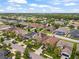 Aerial view of a neighborhood with manicured lawns, mature trees, and a serene lake nearby at 11024 Purple Martin Blvd, Riverview, FL 33579