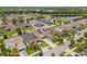 An elevated view of a community featuring a lake, lush greenery, and several homes with solar panels at 11024 Purple Martin Blvd, Riverview, FL 33579