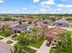 A neighborhood aerial shot showcases manicured lawns, mature trees, and home solar panels at 11024 Purple Martin Blvd, Riverview, FL 33579