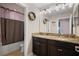 Bathroom with a double sink vanity, granite countertop, dark cabinets, and shower at 11024 Purple Martin Blvd, Riverview, FL 33579