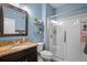 Bathroom with granite vanity, modern glass shower, and light blue walls at 11024 Purple Martin Blvd, Riverview, FL 33579