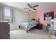 bedroom featuring a bed with wooden frame, ceiling fan, pink accent wall, and natural light at 11024 Purple Martin Blvd, Riverview, FL 33579