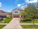 Charming two-story home with a well-manicured lawn, lush landscaping, and a large driveway at 11024 Purple Martin Blvd, Riverview, FL 33579