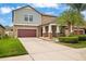 Traditional two-story home with a two-car garage, covered porch with rocking chairs at 11024 Purple Martin Blvd, Riverview, FL 33579