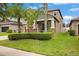 Suburban home showcasing a lush lawn, manicured landscaping, and a covered front porch at 11024 Purple Martin Blvd, Riverview, FL 33579