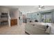 Open-concept living space with a kitchen, bar-top seating, stairs, and access to the outdoor living area at 11024 Purple Martin Blvd, Riverview, FL 33579
