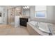 Bathroom featuring soaking tub, glass shower and vanity with granite counters at 11024 Purple Martin Blvd, Riverview, FL 33579