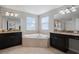Well lit bathroom featuring granite countertops, dual sinks and a soaking tub at 11024 Purple Martin Blvd, Riverview, FL 33579