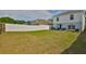 A large lawn, a patio with a grill, and a white vinyl fence at 11438 Ivy Flower Loop, Riverview, FL 33578