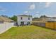 Spacious fenced backyard featuring a well-maintained lawn and outdoor dining area at 11438 Ivy Flower Loop, Riverview, FL 33578