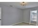 This bedroom has neutral walls, carpet, and a large window at 11438 Ivy Flower Loop, Riverview, FL 33578