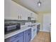 Well-lit kitchen featuring white cabinets, gray base cabinets, and stainless-steel appliances for a modern look at 11438 Ivy Flower Loop, Riverview, FL 33578