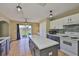 Bright kitchen featuring white cabinets, gray base cabinets, an island, and a view of the outdoor space at 11438 Ivy Flower Loop, Riverview, FL 33578