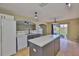 Spacious kitchen with white cabinets and gray island, equipped with modern appliances and ample storage space at 11438 Ivy Flower Loop, Riverview, FL 33578