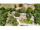 Aerial view of house surrounded by lush trees; featuring a pool and detached garage at 11945 Darwin Ave, New Port Richey, FL 34654