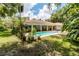 Lush backyard featuring a sparkling pool, brick patio, and beautiful landscaping, perfect for relaxation at 11945 Darwin Ave, New Port Richey, FL 34654
