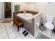 Bright bathroom features a corner jacuzzi tub, glass-enclosed shower, and adjacent toilet at 11945 Darwin Ave, New Port Richey, FL 34654