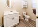 Compact bathroom with modern fixtures and sleek white vanity and matching toilet at 11945 Darwin Ave, New Port Richey, FL 34654